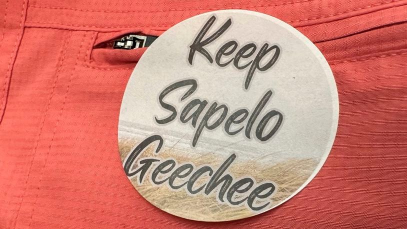 A sticker saying "Keep Sapelo Geechee" is worn on the shirt of George Grovner, a resident of the Hog Hammock community on Sapelo Island, during a meeting of McIntosh County commissioners Tuesday in Darien. Commissioners voted to double the maximum size of homes allowed in the tiny community of people known as Gullah Geechee, who are descended from the enslaved people who worked coastal plantations. Residents say they fear the zoning change will raise their property values and taxes, potentially forcing them to sell their land. (AP Photo/Ross Bynum)