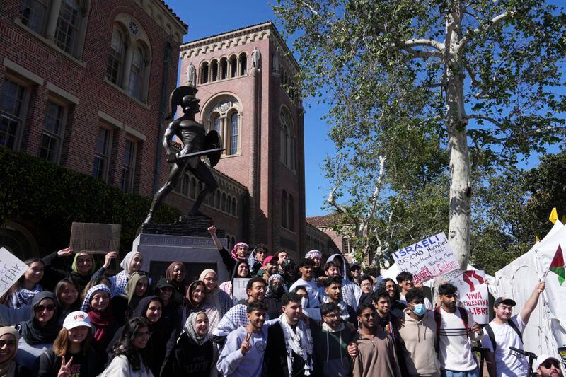 Pro-Palestinian students pose for photos in front of the Tommy Trojan statue on the campus of the University of Southern California during a protest of the 2024 valedictorian Asna Tabassum canceled commencement speech on Thursday, April 18, 2024. The University of Southern California canceled the commencement speech by its 2024 valedictorian who has publicly supported Palestinians, citing security concerns, a rare decision that was praised by several pro-Israel groups and lambasted by free speech advocates and the country's largest Muslim civil rights organization. (AP Photo/Damian Dovarganes)