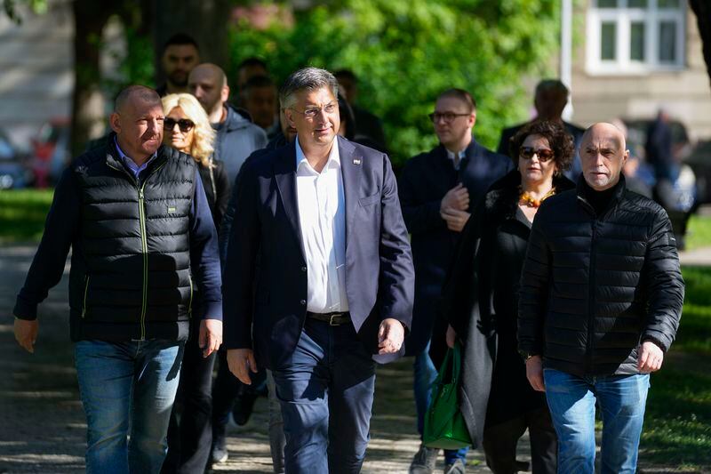 Prime Minister incumbent Andrej Plenkovic, center, leaves a polling station after voting at a polling station in Zagreb, Croatia, Wednesday, April 17, 2024. Croatia is voting in a parliamentary election after a campaign that centered on a bitter rivalry between the president and prime minister of the small European Union and NATO member. (AP Photo/Darko Vojinovic)