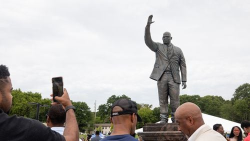 A man takes a photo of the new John Lewis statue at Rodney Cook, Sr. Park in Vine City in Atlanta, GA., on Wednesday, June 7, 2021. (Photo/ Jenn Finch for the Atlanta Journal Constitution)