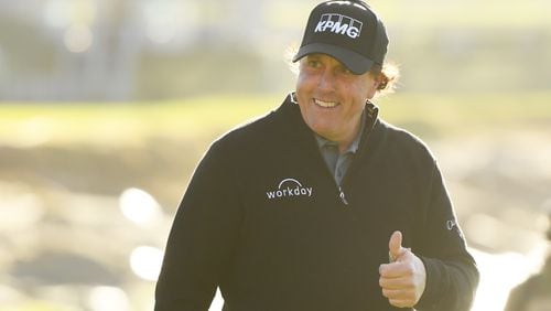 Phil Mickelson shows his pleasure, walking up the 18th at Pebble Beach Monday with a comfortable lead.
