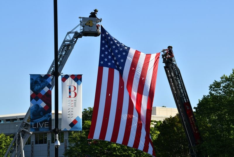 The Smyrna fire Department hangs an American flag on the way to the Truist Park before the start of the funeral service for Smyrna Officer Christopher Ewing on Friday, May 1, 2020. (Hyosub Shin / Hyosub.Shin@ajc.com)