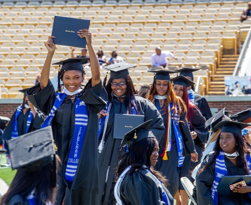 Kat Jackson shows off her diploma after earning her international studies degree in 2020.  Spelman College holds commencement for the class of 2020 at Bobby Dodd Stadium on Sunday, May 16, 2021.  (Jenni Girtman for The Atlanta Journal-Constitution