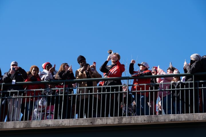 Fans photograph a trumpeter on a pedestrian bridge over the Dawg Walk before the UGA football celebration Saturday, Jan. 14, 2023 in Athens. Ben Gray for the Atlanta Journal-Constitution