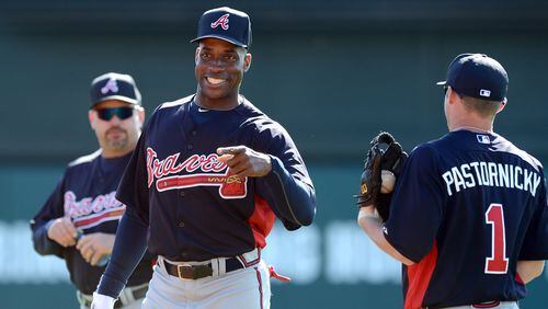 Former Braves Fred McGriff first baseman talks with infielder Tyler Pastornicky during fielding drills.