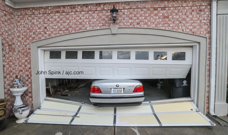 The impact pushed a BMW out of the garage.