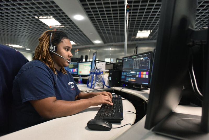DeKalb County dispatcher Deanna Holmes assists a caller at 911 emergency center in Tucker. American Medical Response handles requests for ambulance services, under a contract with the county. HYOSUB SHIN / HSHIN@AJC.COM