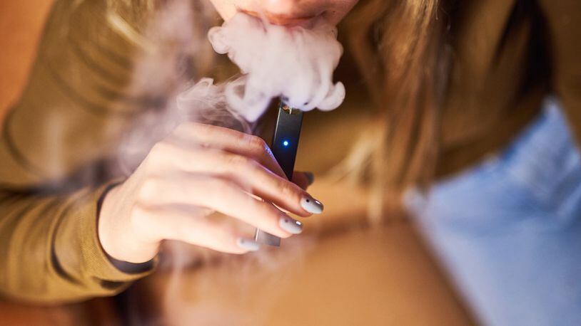 A person smokes a Juul Labs e-cigarette in an arranged photograph. CREDIT: Bloomberg photo by Gabby Jones.