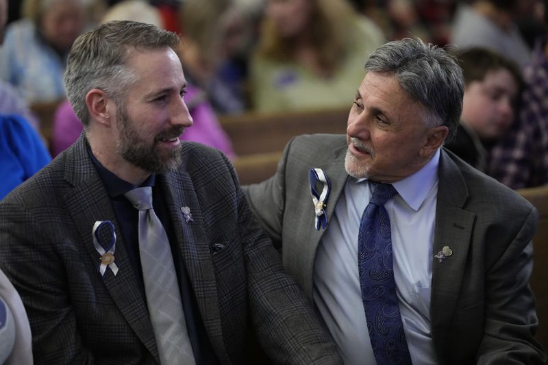 Nathan Hochhalter, left, talks with former principal Frank DeAngelis during a vigil remembering the 25th anniversary of the Columbine High School mass shooting, Friday, April 19, 2024, in Denver. (AP Photo/Jack Dempsey)