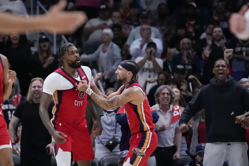 New Orleans Pelicans guard Jose Alvarado, right, celebrates with forward Naji Marshall after Marshall's 3-point basket in the first half of an NBA basketball play-in tournament game against the Sacramento Kings in New Orleans, Friday, April 19, 2024. (AP Photo/Gerald Herbert)