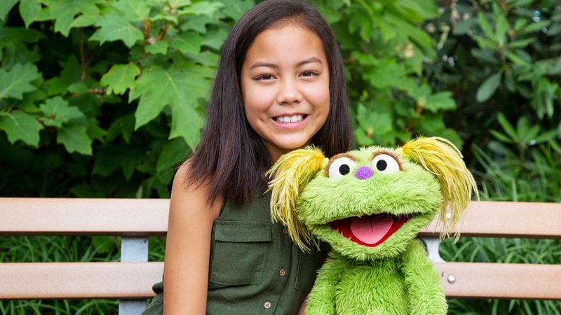 This undated image released by Sesame Workshop shows 10-year-old Salia Woodbury, whose parents are in recovery, with "Sesame Street" character Karli. Sesame Workshop is addressing the issue of addiction.