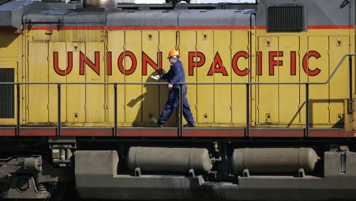 FILE - A maintenance worker walks past the company logo on the side of a locomotive in the Union Pacific Railroad fueling yard in north Denver, Oct. 18, 2006. Four railroads, including Union Pacific, have asked federal appeals courts to throw out a new rule that would require two-person train crews in most circumstances. (AP Photo/David Zalubowski, File)