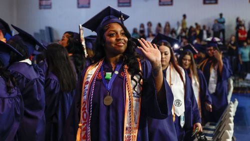 La’Vereeya Cooper waves at a family member during Clayton State University’s spring 2024 graduation ceremony on Friday, May 3, 2024. (Natrice Miller/ AJC)