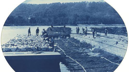 This photo from the National Gallery of Art and made available via the New Orleans Museum of Art, shows a cyanotype made in 1891 by Army Corps of Engineers employee Henry Peter Bosse, of construction of a rock and brush dam on the upper Mississippi River. The photograph is among more than 150 to be shown at the New Orleans Museum of Art in an exhibit of early U.S. landscapes east of the Mississippi. The exhibit originated at the National Gallery; New Orleans is its only other stop. (Henry Peter Bosse/Army Corps of Engineers via AP)
