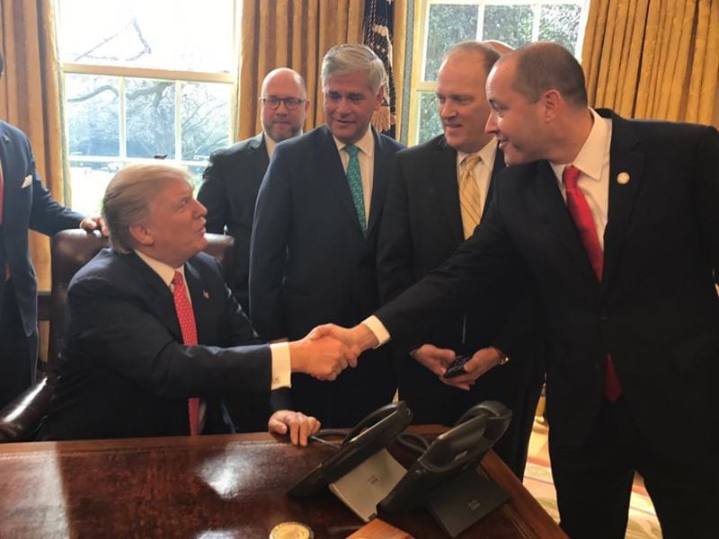 Attorney General Chris Carr shakes hands with then-President Donald Trump. Facebook.