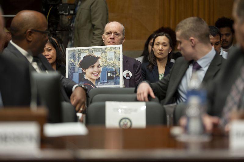 Chris Moore, center, holds a photo of his daughter Danielle Moore, who died in the March 2019 crash of Ethiopian Airlines flight 302, during a Senate Homeland Security and Governmental Affairs - Subcommittee on Investigations hearing to examine Boeing's broken safety culture on Wednesday, April 17, 2024, in Washington. (AP Photo/Kevin Wolf)