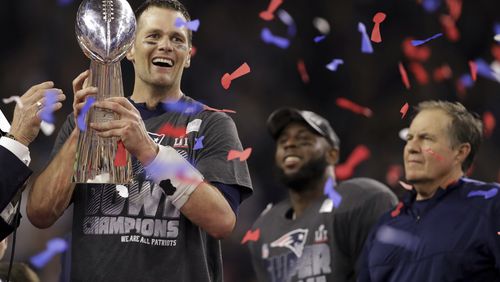 New England Patriots' Tom Brady holds the Vince Lombardi Trophy after defeating the Atlanta Falcons in overtime at the NFL Super Bowl 51 football game Sunday, Feb. 5, 2017, in Houston. The Patriots defeated the Falcons 34-28. At right is Patriots head coach Bill Belichick. (AP Photo/Darron Cummings)