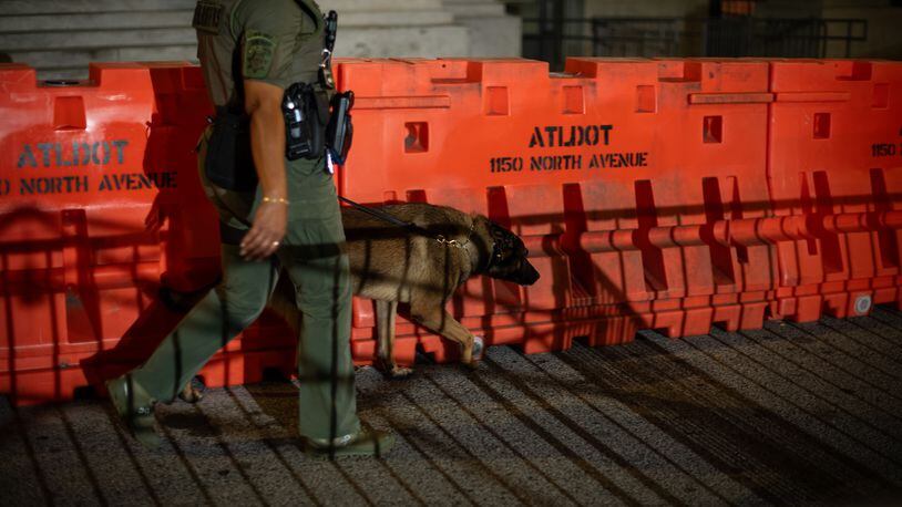 
                        A deputy walks a barricade erected before dawn outside the Fulton County Courthouse in Atlanta, on Aug. 15, 2023. Police said Thursday that they were investigating online threats against the grand jurors who voted this week to indict Donald Trump and 18 others; the jurors’ names are public record under Georgia law. (Hilary Swift/The New York Times)
                      