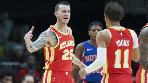 Atlanta Hawks guard Garrison Mathews (25) celebrates a play with guard Trae Young (11) during the first half against the Detroit Pistons at State Farm Arena, Monday, December 18, 2023, in Atlanta. (Jason Getz / Jason.Getz@ajc.com)