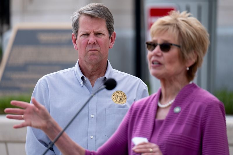 Gov. Brian Kemp listens as Kathleen Toomey, commissioner of the Georgia Department of Public Health, answers a journalist’s question during a press conference outside of the State Capitol on April 13, 2020. (Ben Gray for The Atlanta Journal-Constitution)