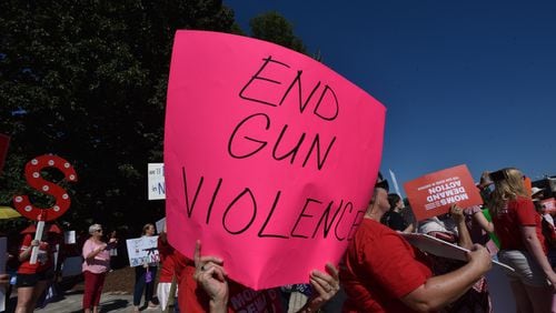 Rally participants hold signs during a rally for stronger gun laws at Decatur Square on Saturday, August 17, 2019.  (Hyosub Shin / Hyosub.Shin@ajc.com)