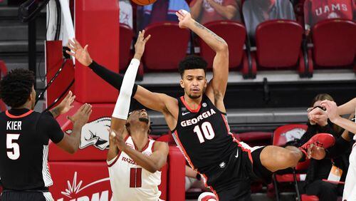 Arkansas guard Jalen Tate (11) is fouled by Georgia defender Toumani Camara (10) during the first half of an NCAA college basketball game Saturday, Jan. 9, 2021, in Fayetteville, Ark. (AP Photo/Michael Woods)