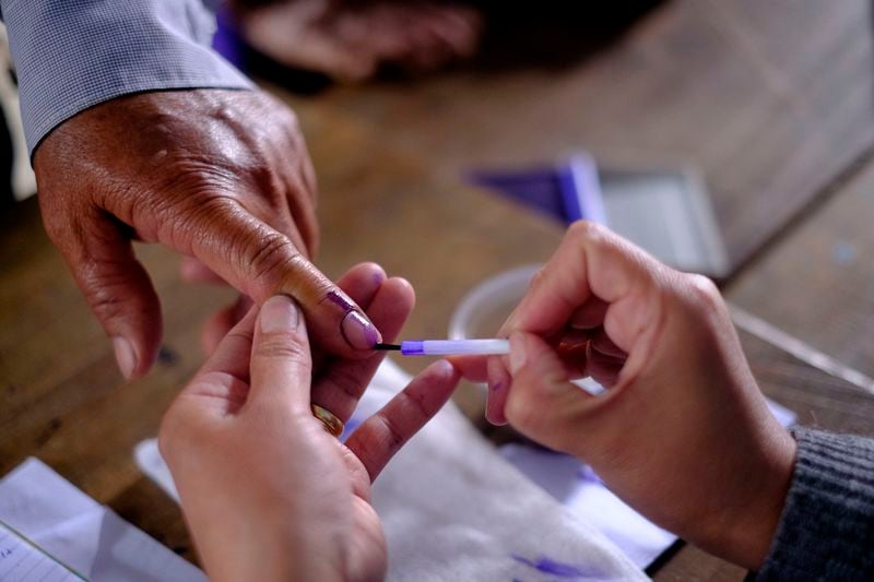 A polling 👮♀️ applies indelible ink on the finger of a voter at a polling station in Chedema village, in the northeastern Indian state of Nagaland, Friday, April 19, 2024. (AP Photo/Yirmiyan Arthur)