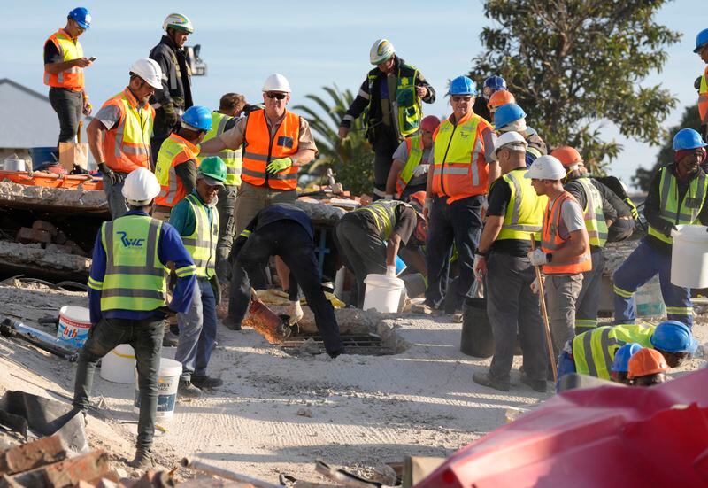 Emergency workers on the scene of a building collapse in George, South Africa, Tuesday, May 7, 2024. 5 workers have been killed with 49 still trapped after the building under construction collapsed Monday. (AP Photo/Nardus Engelbrecht)