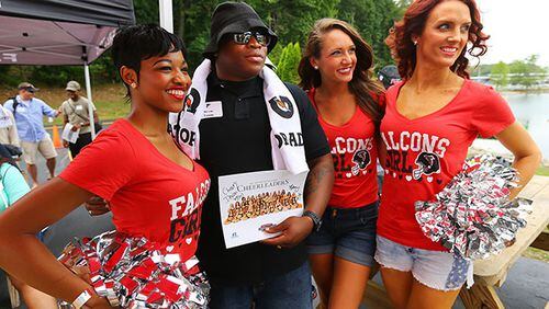 U.S. Army Iraq and Afghanistan veteran Devon Young has his picture taken with cheerleaders Kiva (from left to right), Megan, and Kiley while the Atlanta Falcons pay tribute to wounded military veterans from Iraq and Afghanistan with a fishing outing and cook out in it's seventh year at Lake Lanier on Wednesday, June 11, 2014, in Buford. CURTIS COMPTON / CCOMPTON@AJC.COM