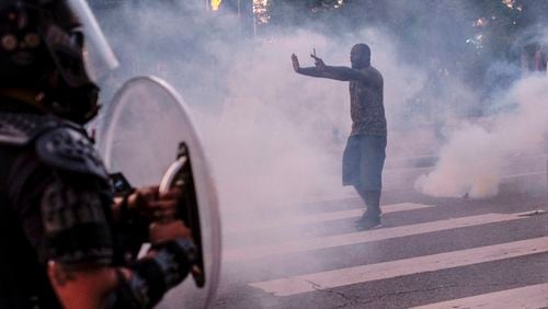 A protestor tries to talk the police back amid tear gas in downtown Atlanta as protests continued for a third day.  Protests over the death of George Floyd in Minneapolis police custody continued around the United States, as his case renewed anger about others involving African Americans, police and race relations.    Ben Gray for the Atlanta Journal Constitution