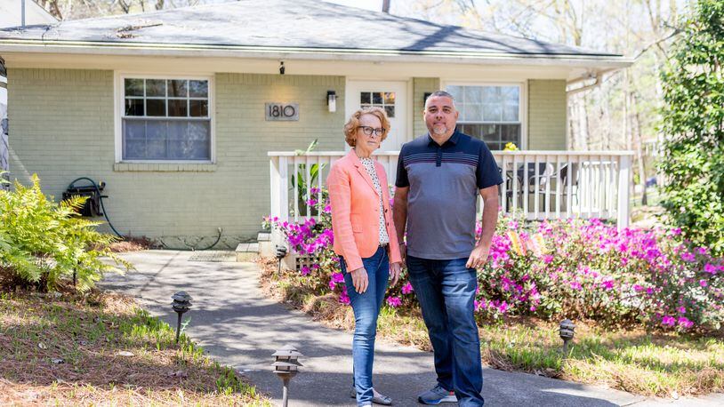 Rich Munroe and Kathie McClure, president and vice president of the Atlanta Metro Short Term Rental Alliance, pose for a photo in front of a rental home owned by McClure in the Piedmont Heights neighborhood on Friday. (Photo/Jenn Finch)