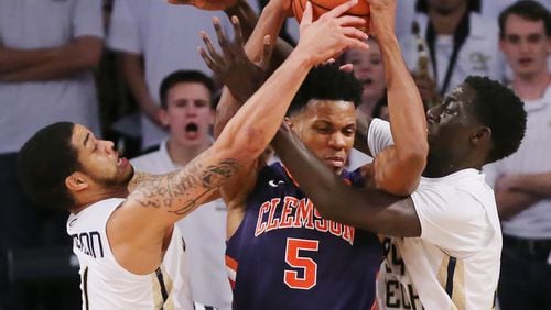 Georgia Tech defenders Josh Heath (left) and Abdoulaye Gueye force a turnover on a double team against Clemson forward Jaron Blossomgame during an NCAA basketball game on Thursday, Jan. 12, 2017, in Atlanta. Curtis Compton/ccompton@ajc.com