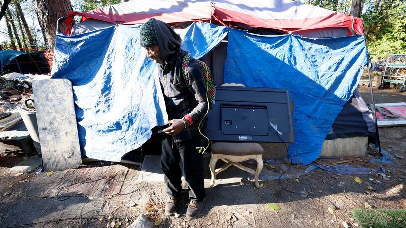 In January 2022, 640 people in Atlanta were living outside in places like the Buckhead encampment known as "The Hill,"  where a brush fire recently destroyed almost 20 tents. Project Community Connections Inc. works with unhoused clients to help them find housing. The nonprofit recently launched a cash transfer program in the hopes that data will show the importance of cash assistance in stabilizing those most in need.  Miguel Martinez / miguel.martinezjimenez@ajc.com