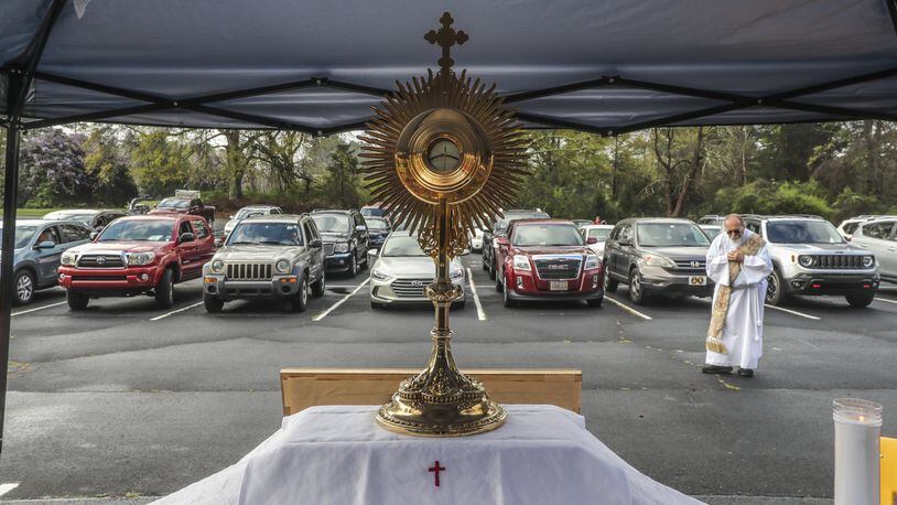 Deacon Fred Johns presided over “Drive-In” Adoration of the Most Blessed Sacrament in March. Some 50-cars attended in the parking lot at St. Pius X Catholic Church in Conyers. Since the COVID-19 outbreak, Catholics in the Atlanta Archdiocese and around the world have been implementing creative ways to serve the faithful. JOHN SPINK/JSPINK@AJC.COM