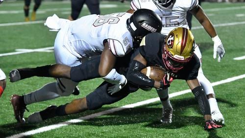 Johns Creek WR Dalton Pearson is tackled by Alpharetta's Breon Smith during Friday's game. (John Amis/Special)