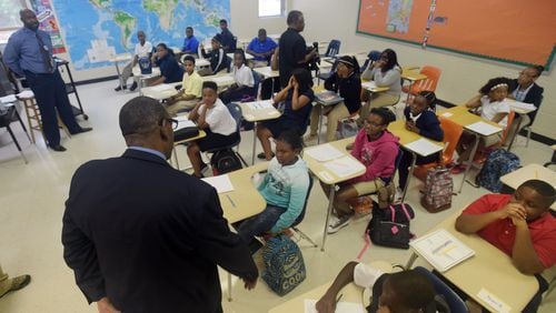 Superintendent Steve Green talks with sixth-grade students in teacher Paul Johnson’s social studies class in Chapel Hill Middle School on the first day of classes in August 2015. The district announced students will attend an extended school day through December to make up days lost to Tropical Storm Irma. KENT D. JOHNSON /KDJOHNSON@AJC.COM