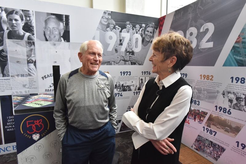 Bill Thorn (left), the only person to complete every running of the Peachtree, and Julia Emmons, Long-time AJC Peachtree Road Race Director and former Atlanta City Councilwoman, share a smile as they talk during a recent unveiling event of traveling display at Lenox Square. HYOSUB SHIN / HSHIN@AJC.COM