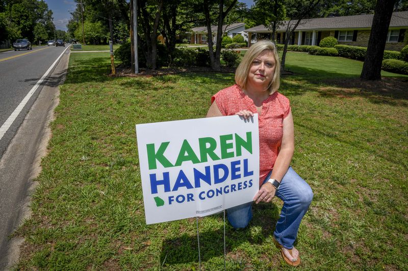 Vikki Thomas is shown with her campaign sign for Karen Handel in her yard, Friday, June 2, 2017, in Roswell, Ga. When a news report came out about Jon Ossoff signs allegedly being stolen on her street, it got her worried about hers’.  (John Amis)