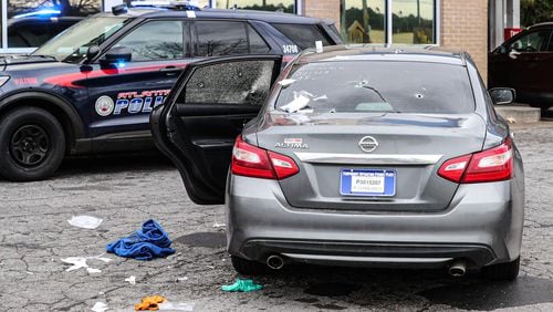 A gray Nissan Altima was found riddled with bullets at the second shooting scene on Campbellton Road. (John Spink / John.Spink@ajc.com)