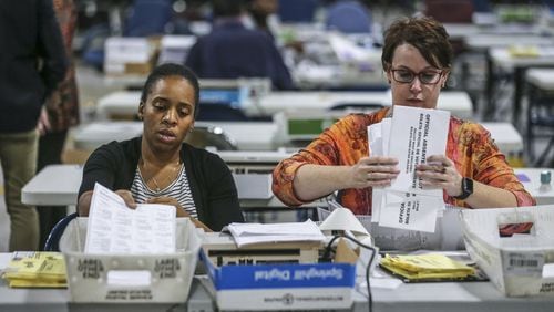 Elections Coordinator, Shantell Black (left) and Elections Deputy Director, Kristi Royston open and scan absentee ballots on Wednesday morning, Nov. 7, 2018 at the Voter Registration and Elections Office in Lawrenceville. JOHN SPINK / JSPINK@AJC.COM