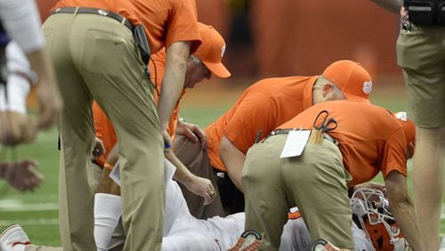 Clemson quarterback Kelly Bryant lies on the field and is attended to by team staff after suffering a concussion during a game earlier this year against Syracuse. Clemson is one of the ACC schools that reported to the AJC that it tracks concussions by sport. Photo by Adrian Kraus/Associated Press.