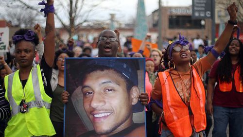 Protesters, including Brandan Marshall holding a photo of Anthony Hill, take to the streets of downtown Decatur to protest Hill’s shooting death on March 9, 2015. Hill was killed by a DeKalb police officer, who later was indicted in the shooting. BEN GRAY / BGRAY@AJC.COM