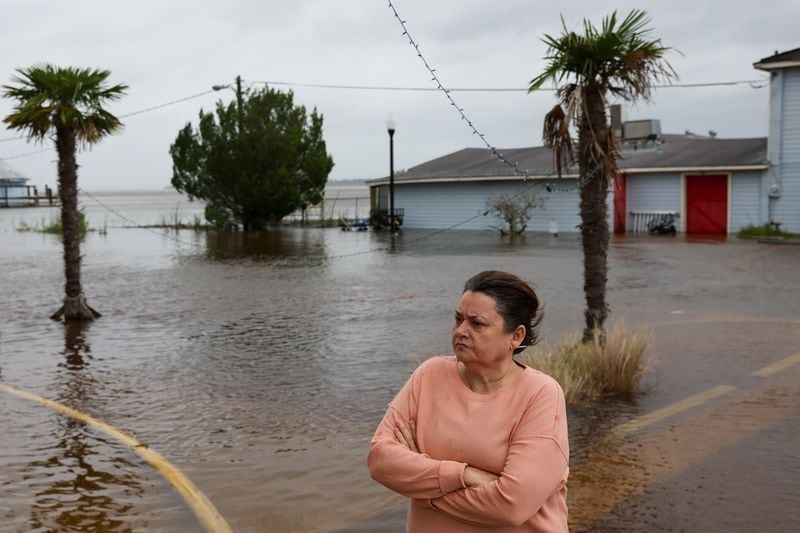 Angie Mock, an owner of Market on the Square general store, looks on as St. Marys Street in St. Marys is flooded during high tide on Thursday, September 29, 2022. (Arvin Temkar / arvin.temkar@ajc.com)