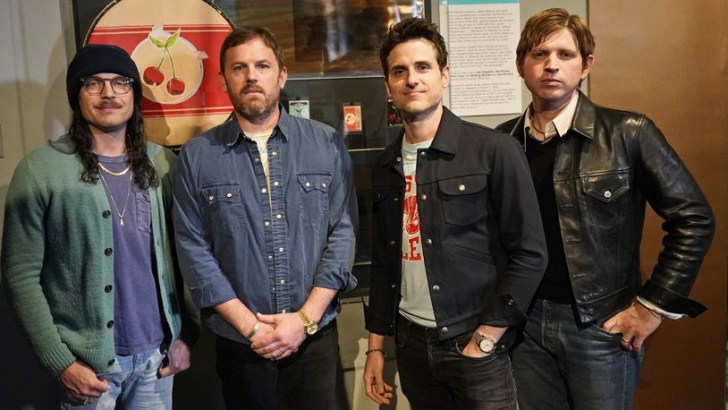 Rockers Kings of Leon, from left, Nathan, Caleb, Jared, and Matthew Followill, pose for a photo in front of their exhibit at the Rock and Roll Hall of Fame Thursday, April 29, 2021, in Cleveland. The band toured a new digital exhibit at the Rock and Roll Hall of Fame for the NFT (non-fungible token) launching before the rock band plays at the NFL draft, Thursday, April 29, 2021, in Cleveland. from left, Nathan, Caleb, Jared, and Matthew Followill are shown. (AP Photo/Tony Dejak)