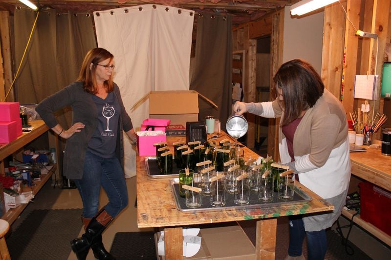 Erica Brown startd making candles in recycled wine bottles as a hobby in 2015. In the years since, her and her mother, Sabrina Watson, have scaled it into a business, Corked Candles. Courtney Kueppers/AJC