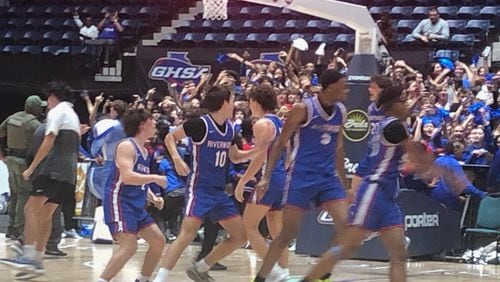 The Riverwood basketball team storms the court after beating Alexander 67-63 in OT in the Class 6A championship game, March 8, 2024, at the Macon Coliseum.