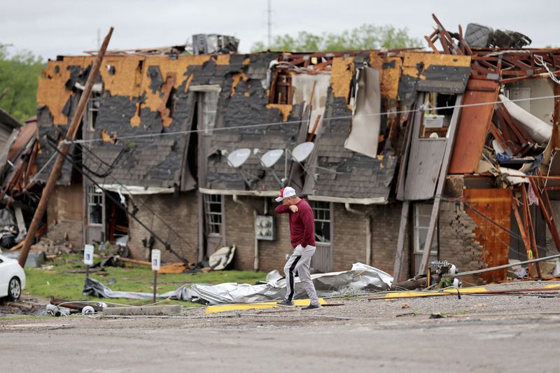 A man walks past tornado damage in Sulphur, Okla., Sunday, April 28, 2024, after severe storms hit the area the night before. (Bryan Terry/The Oklahoman via AP)