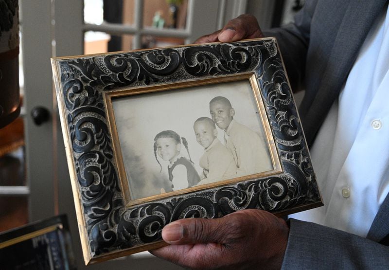 Gary Houston, holds his family photograph (right) with his brother Michael Houston (middle) and sister Whitney Houston (left) at his home, Saturday, March 25, 2023, in Alpharetta. Whitney Houston's estate releases a new album 11 years after the singer's death. (Hyosub Shin / Hyosub.Shin@ajc.com)