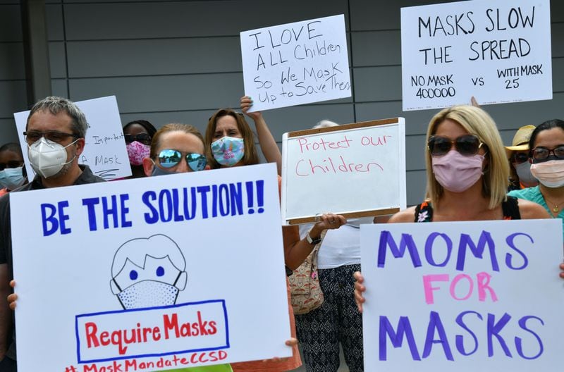 Parents hold a rally to encourage the Cobb County School District to require masks for students and staff at the parking lot of the district's headquarters on Aug. 2, 2021.  (Hyosub Shin / Hyosub.Shin@ajc.com)