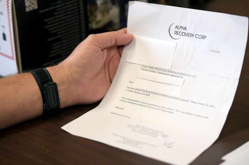 Greensboro, Ga., resident Michael Rowe looks through paperwork that was sent to him concerning past-due fees a debt collector claimed he owed to Confirmatrix Laboratory Inc. JENNA EASON / JENNA.EASON@COXINC.COM